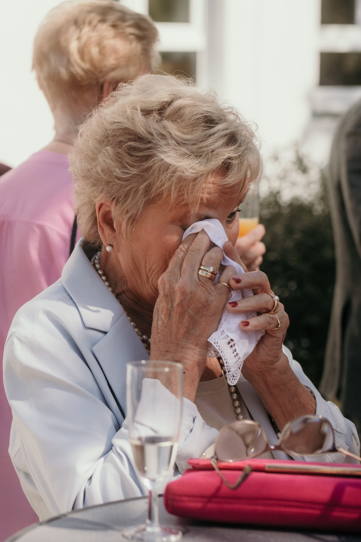 Tränen der Rührung tupft sich diese ältere Dame mit einem Stofftuch aus dem Auge.