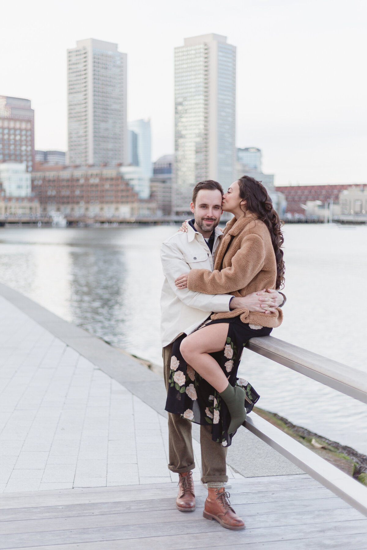 Engaged couple with the Boston skyline in the distance