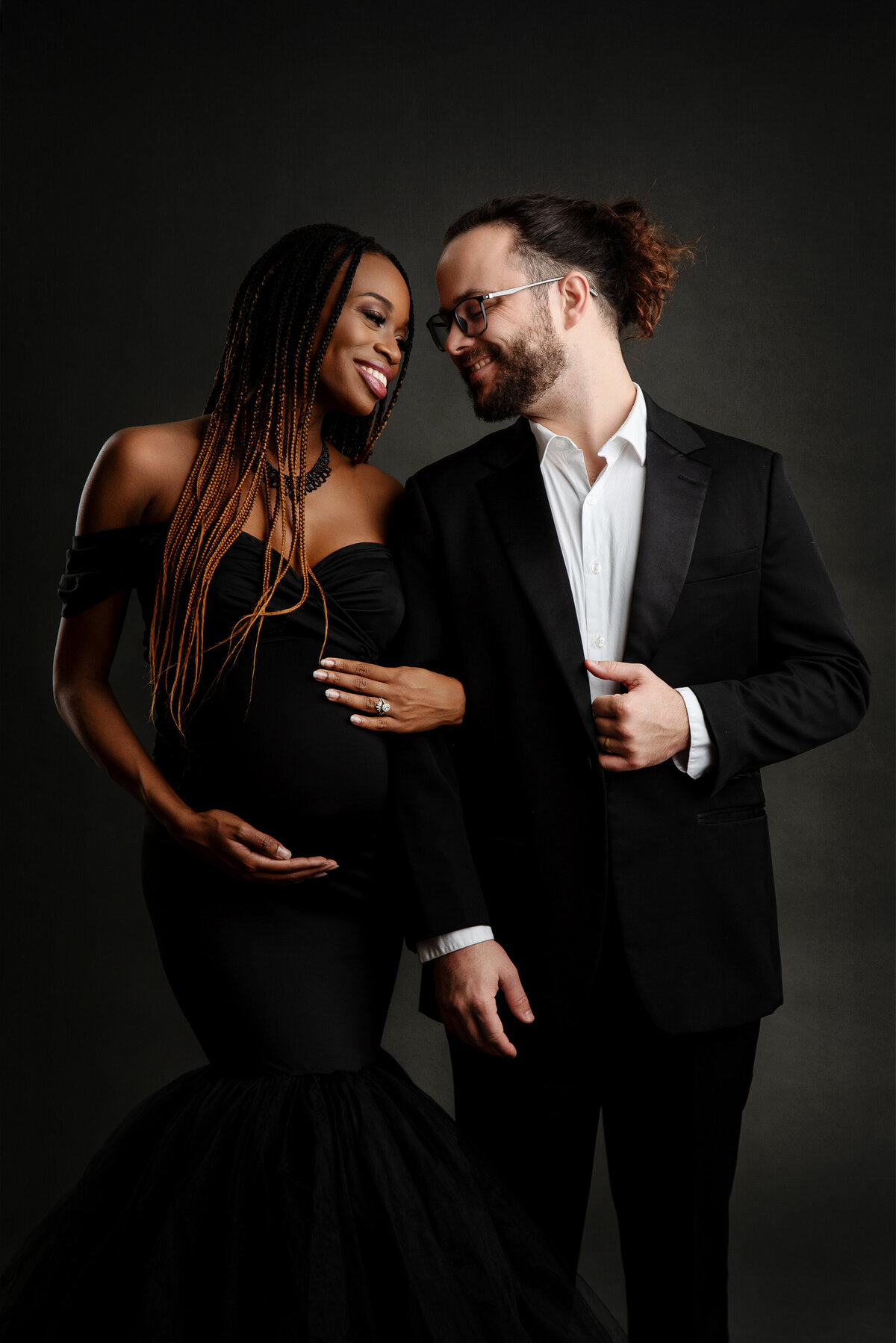 st-louis-maternity-photographer-pregnant-mom-in-black-gown-with-dad-in-black-tux-smiling-at-each-other