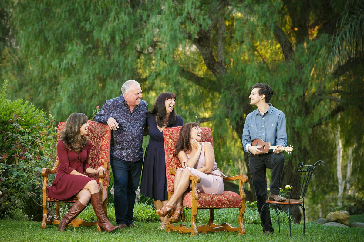 A family of five all together smiling at each other