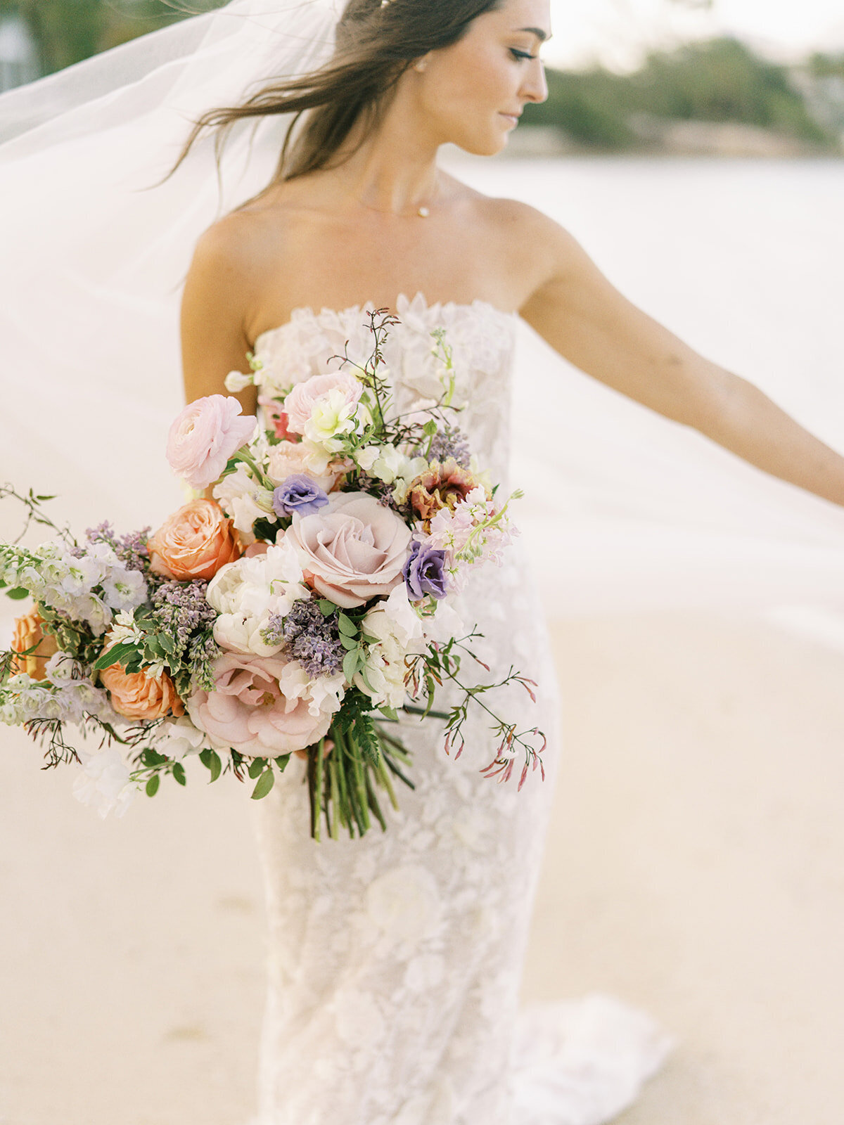 Lush floral heavy bridal bouquet for tropical destination wedding in Exuma, Bahamas. Bouquet in colors of peach, lavender, blush, cream, orange, and pale yellow. Private estate beach wedding. Destination floral design by Rosemary & Finch Floral Design.
