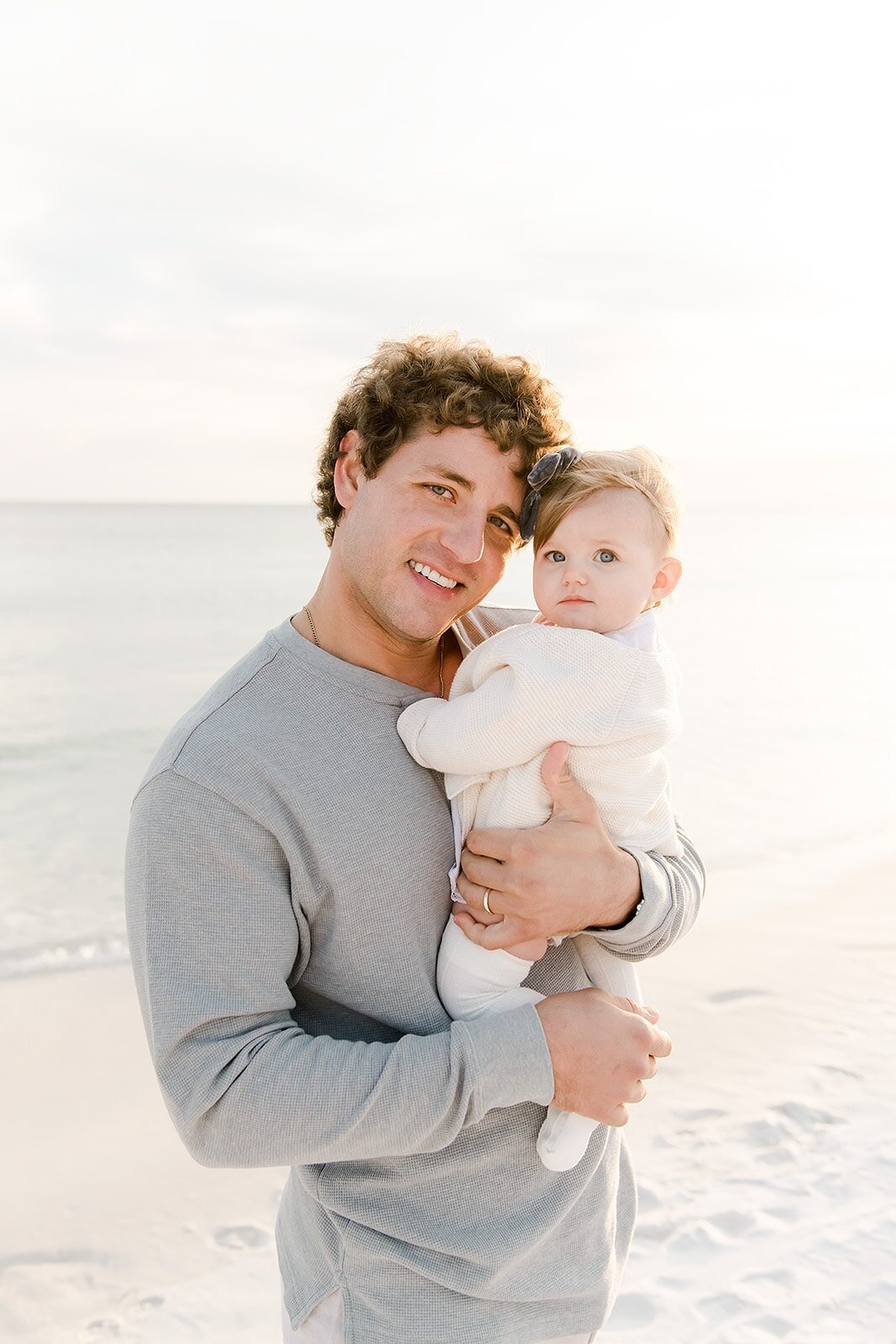 a father and baby smiling into destin family photographers camera