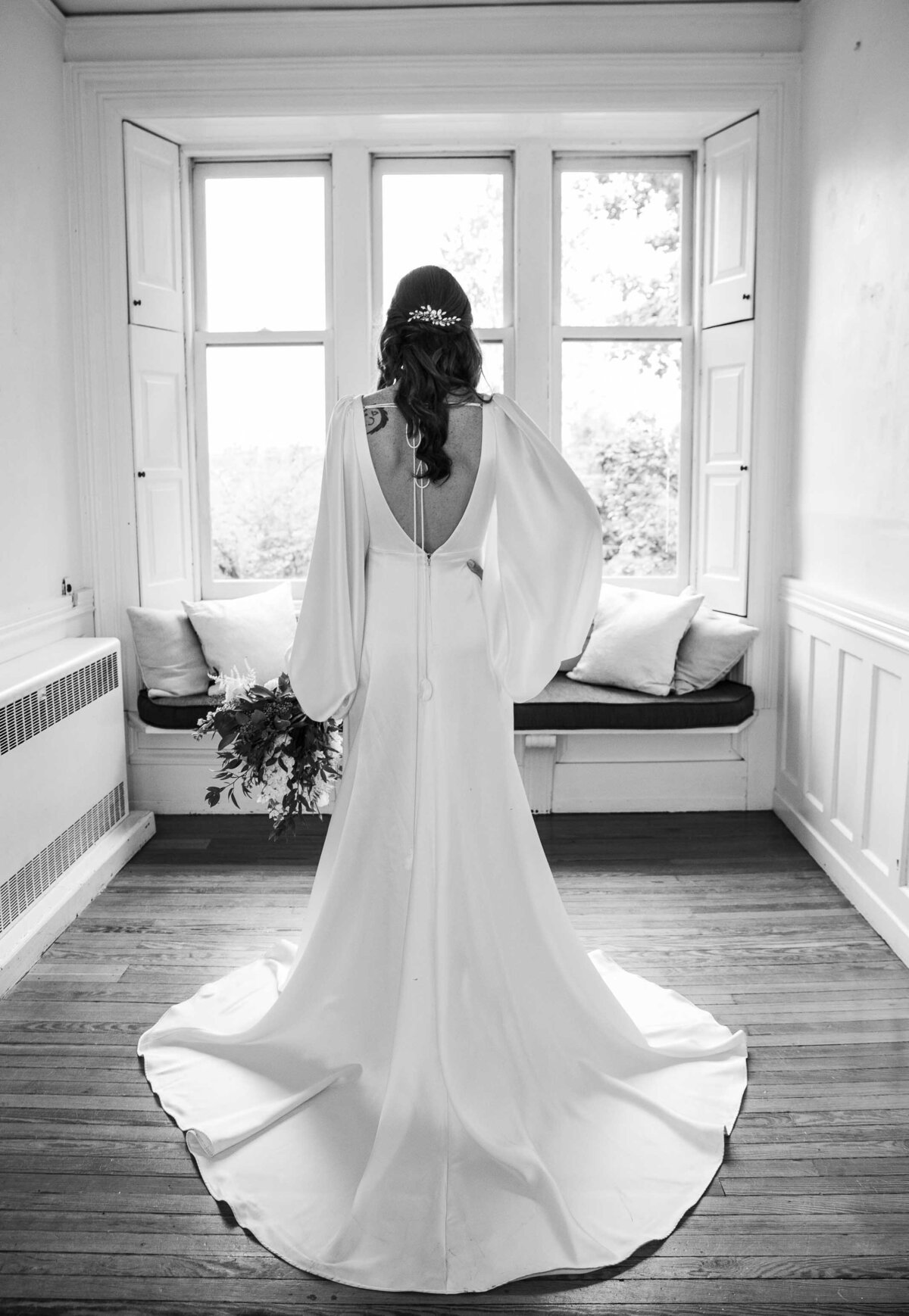 Black and White bridal portrait, back of dress, holding bouquet at Duke Sculpture Garden at Dixon Mansion