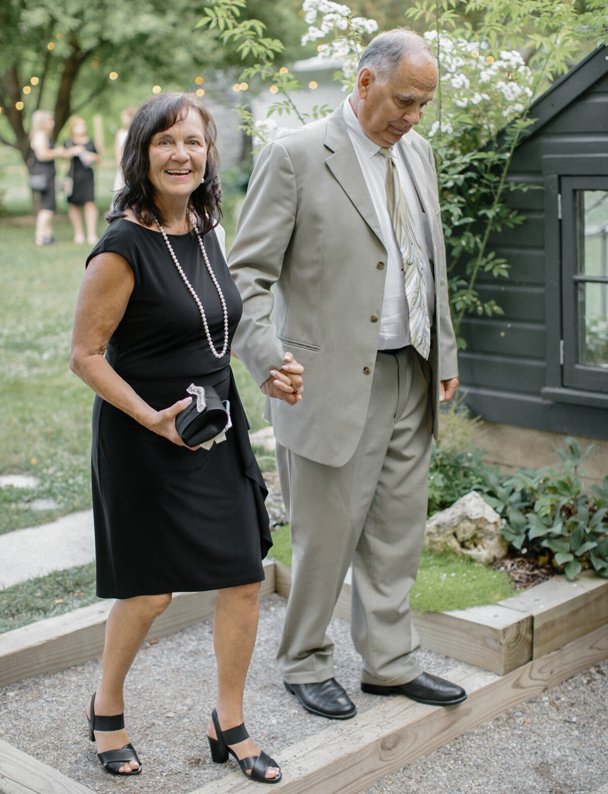 guests smile at Glass House community wedding in Michigan, wedding dinner in greenhouse