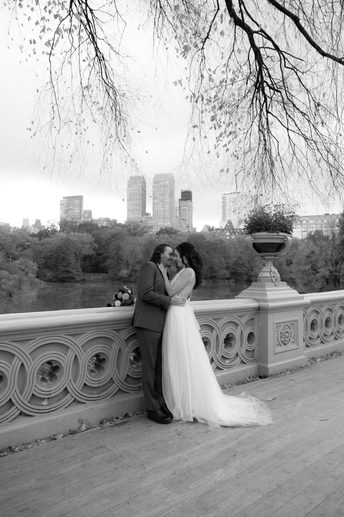 Bride and groom sharing a quiet moment under golden fall trees in Central Park.