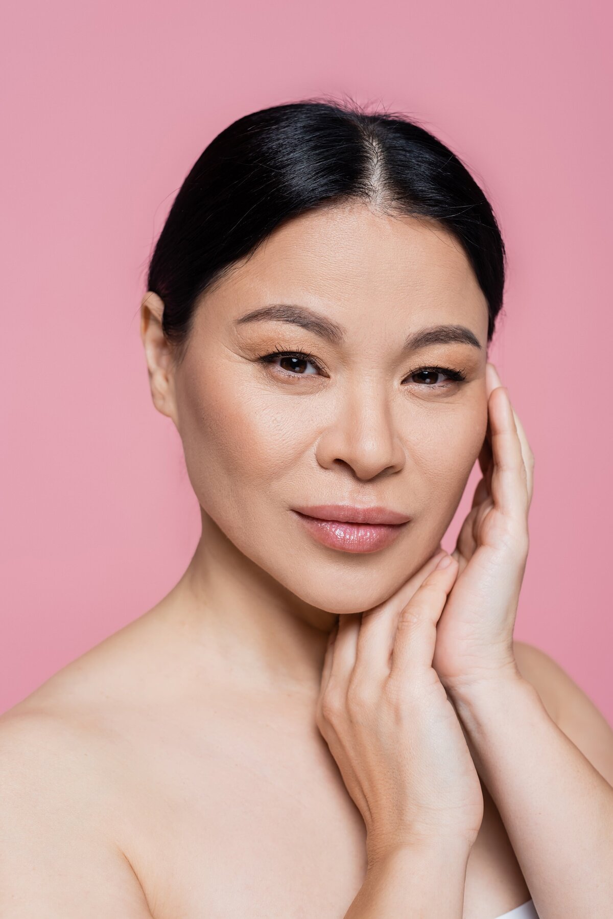 asian-woman-with-naked-shoulders-touching-face-iso-2023-11-27-05-33-21-utc