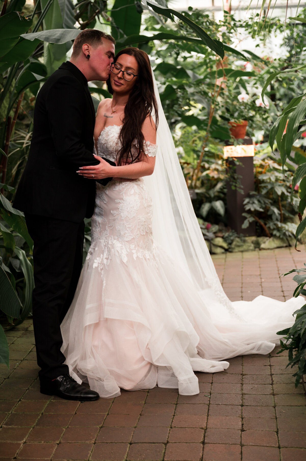 groom kissing bride on the cheek at tropical destination wedding