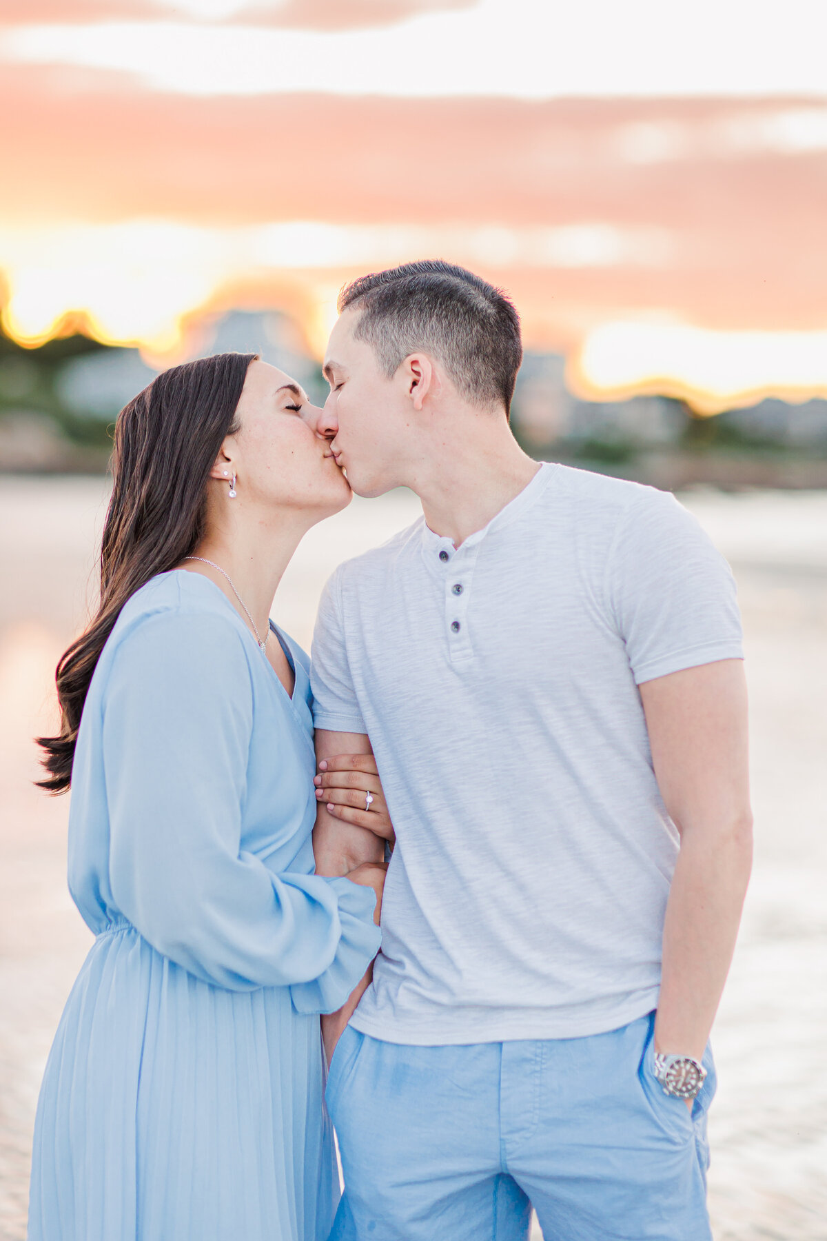 Couple kissing at sunset representing MA beach engagement photos