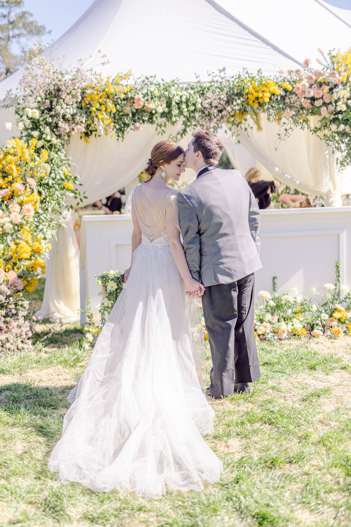 GA bride and groom holding hands under luxury spring themed floral arch