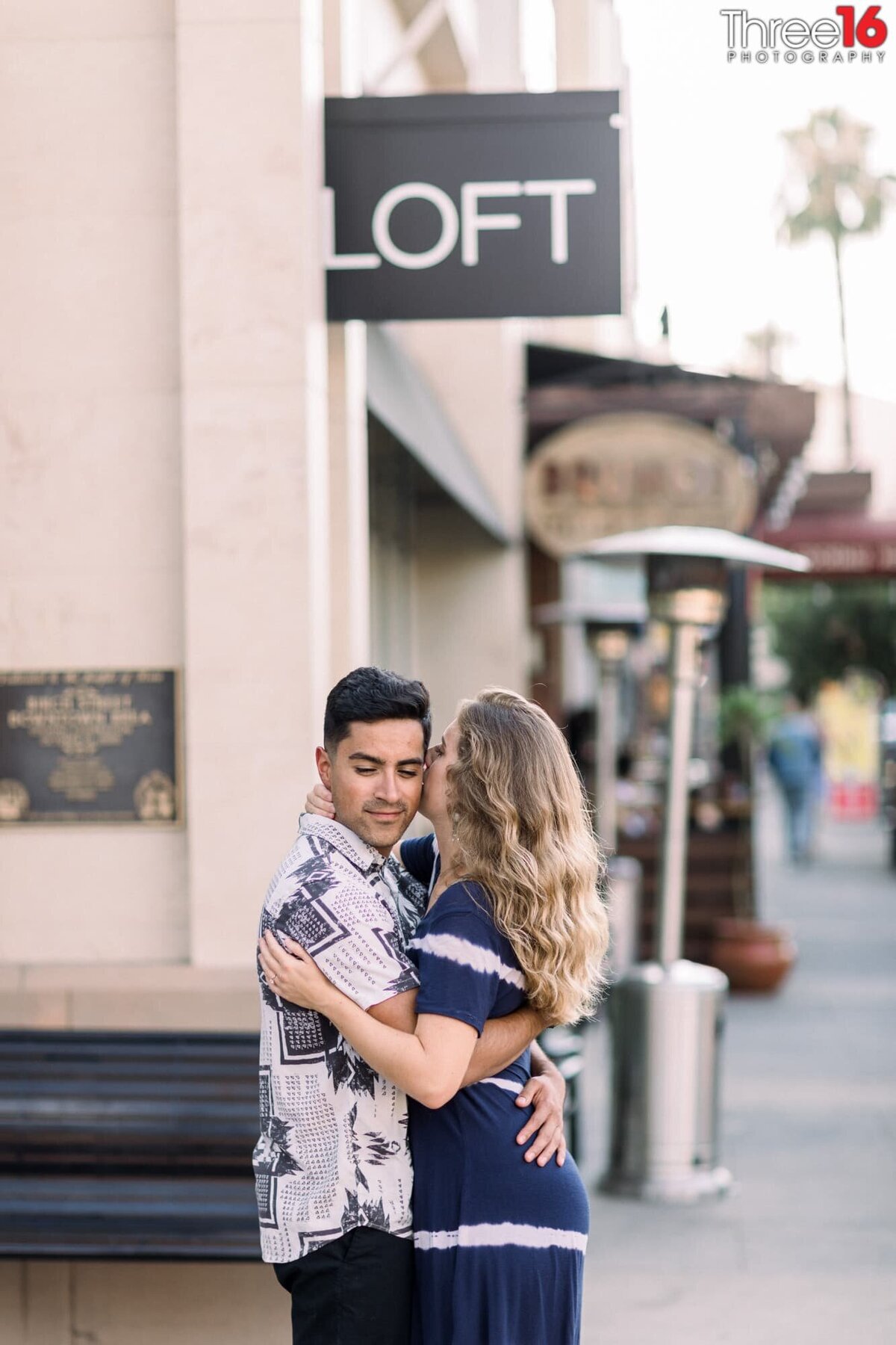 Engaged couple go cheek to cheek in a tender moment during engagement session