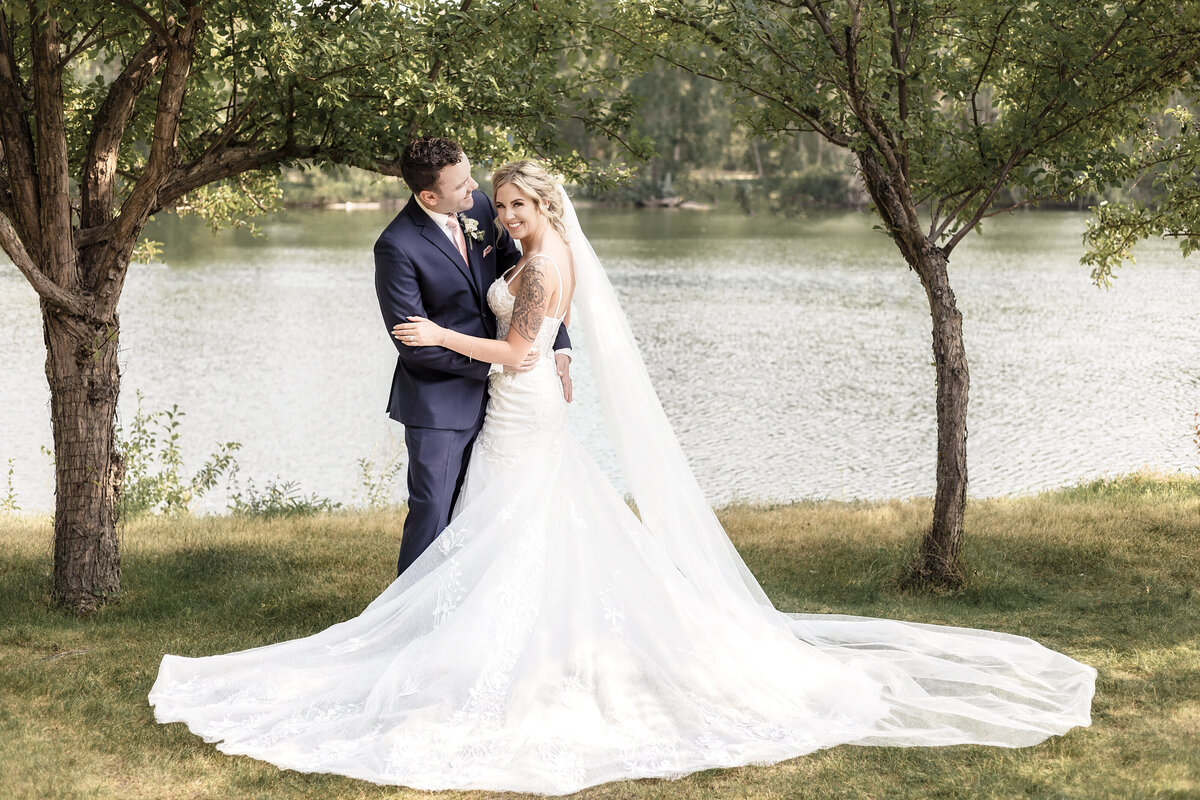 A portrait of a bride and groom along a riverfront in Calgary