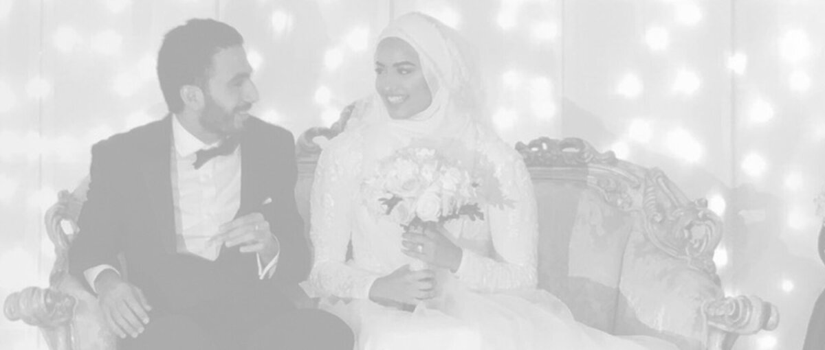 Black and white image of a bride and groom wearing traditional Islamic wedding attire, capturing a timeless and culturally significant moment