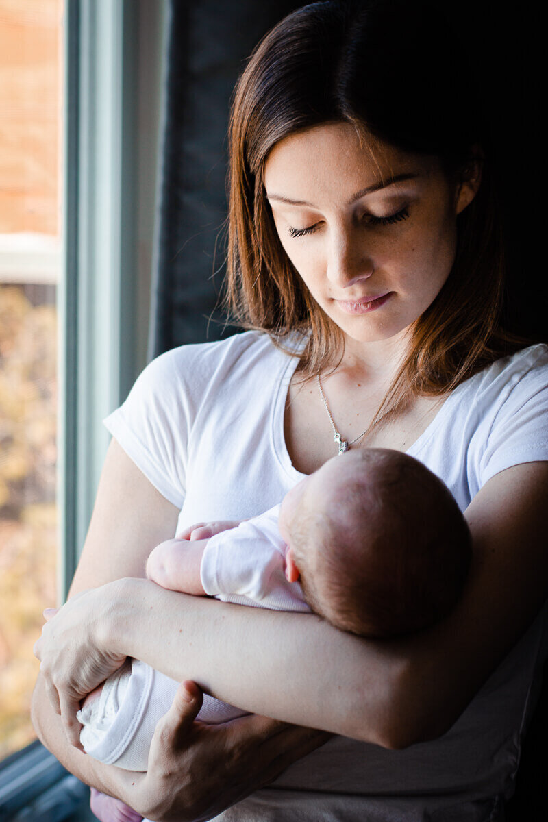 New mother holding her baby for Toronto newborn photography session