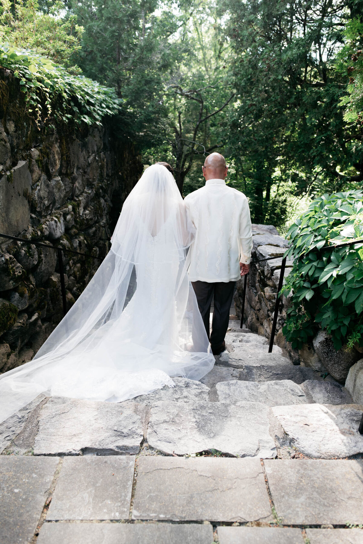 bride walking with father down stone steps