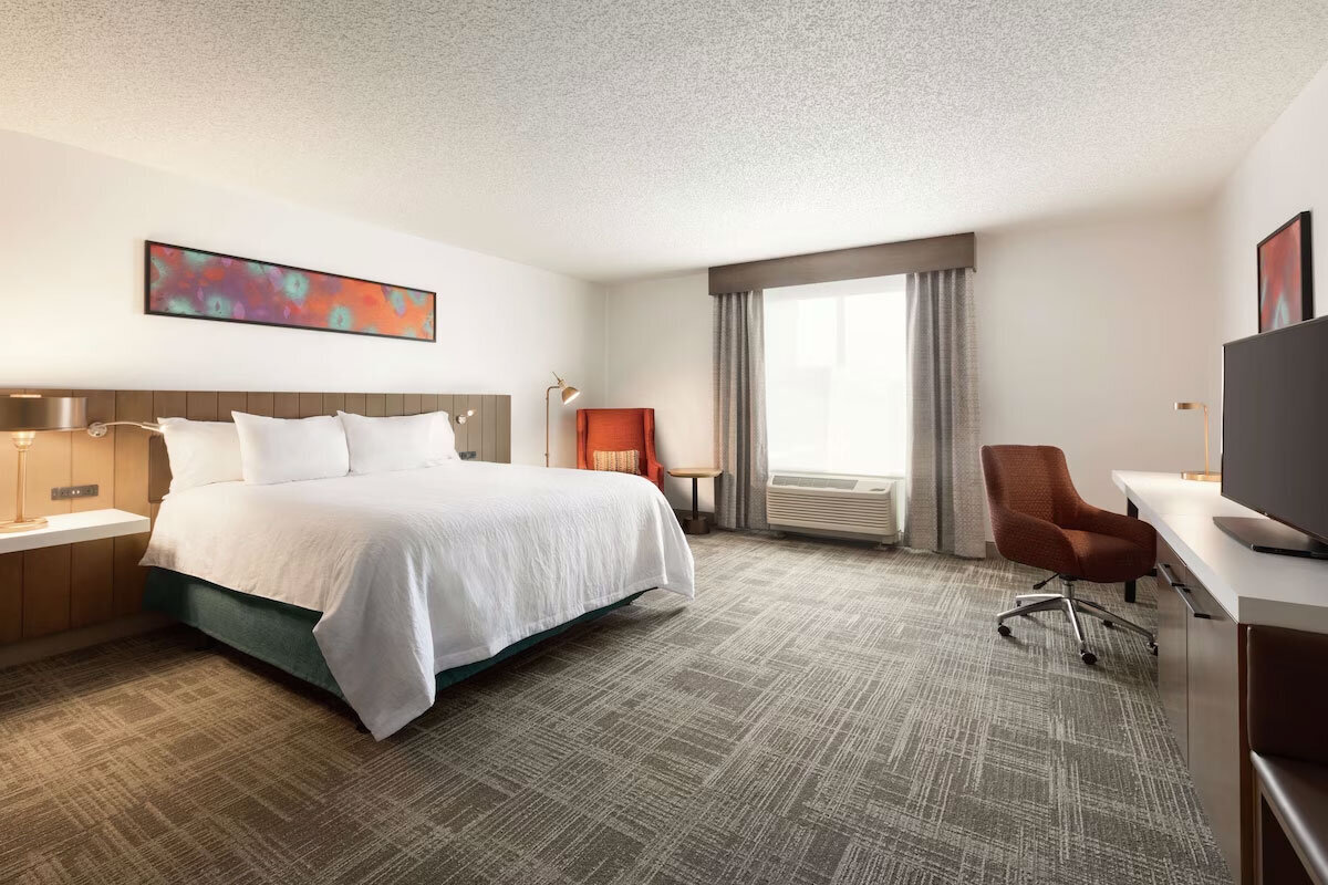 Modern hotel room with red lounge chair