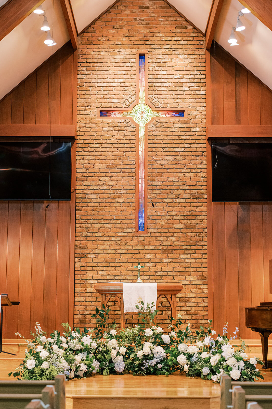 Romantic floral altar installation inside a mountain chapel for a Cashiers NC wedding ceremony.