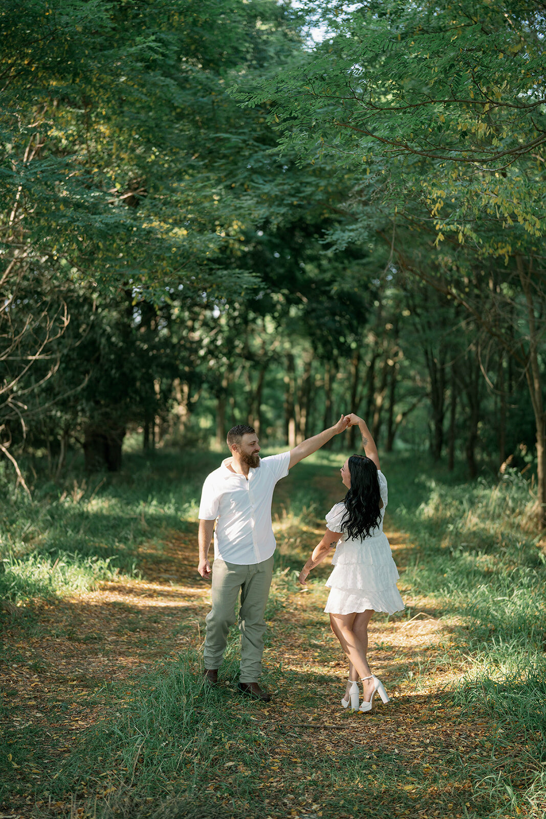 Kali and Joe walking toward each other along a shaded path during their Detroit engagement session.