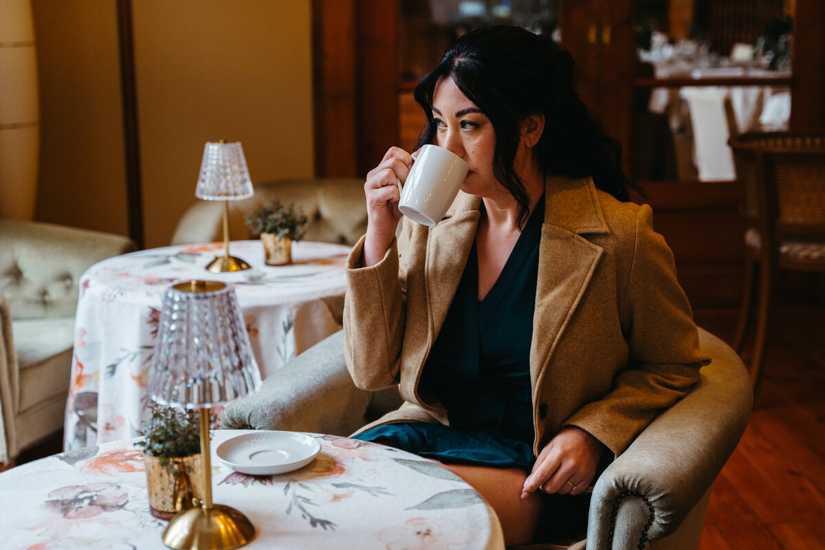 Bride drinking tea inside cozy hotel before wedding