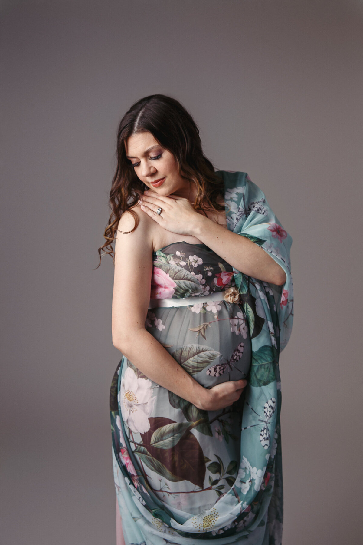 Maternity photo shoot with a beautiful woman wearing a green floral gown