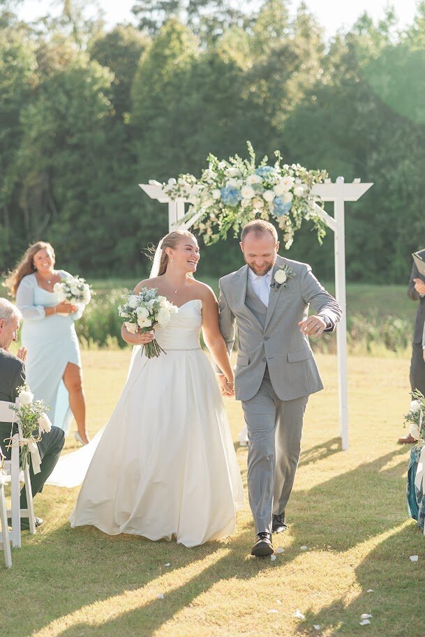 Bride in white wedding dress blowing in wind and floral bouquet
