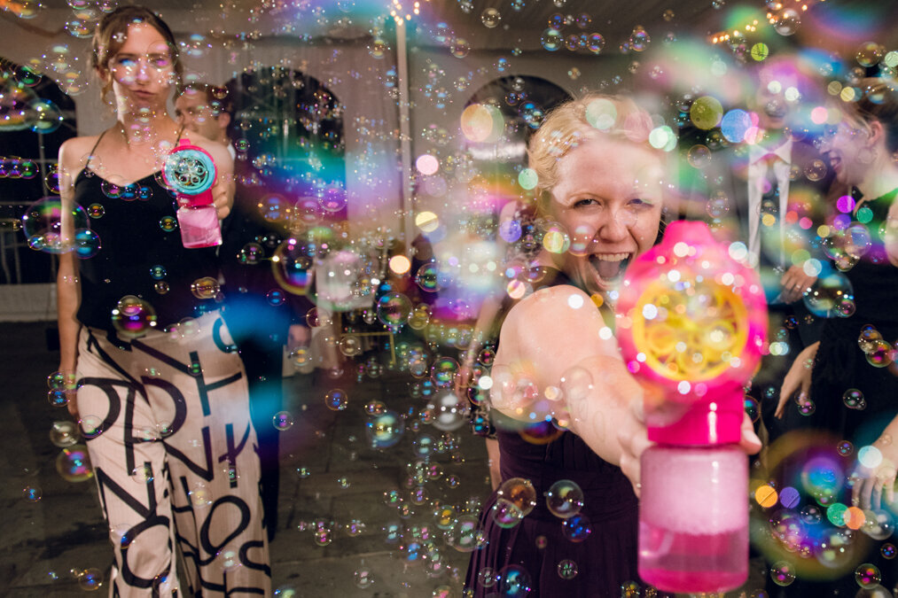 A group of women playing with bubbles at a party.