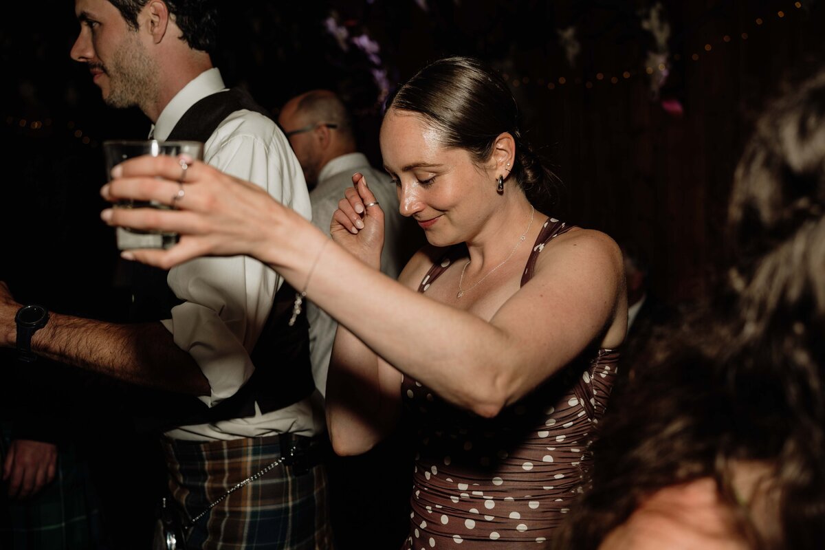 A guest dances during the evening reception of a wedding. She is photographed candidly.