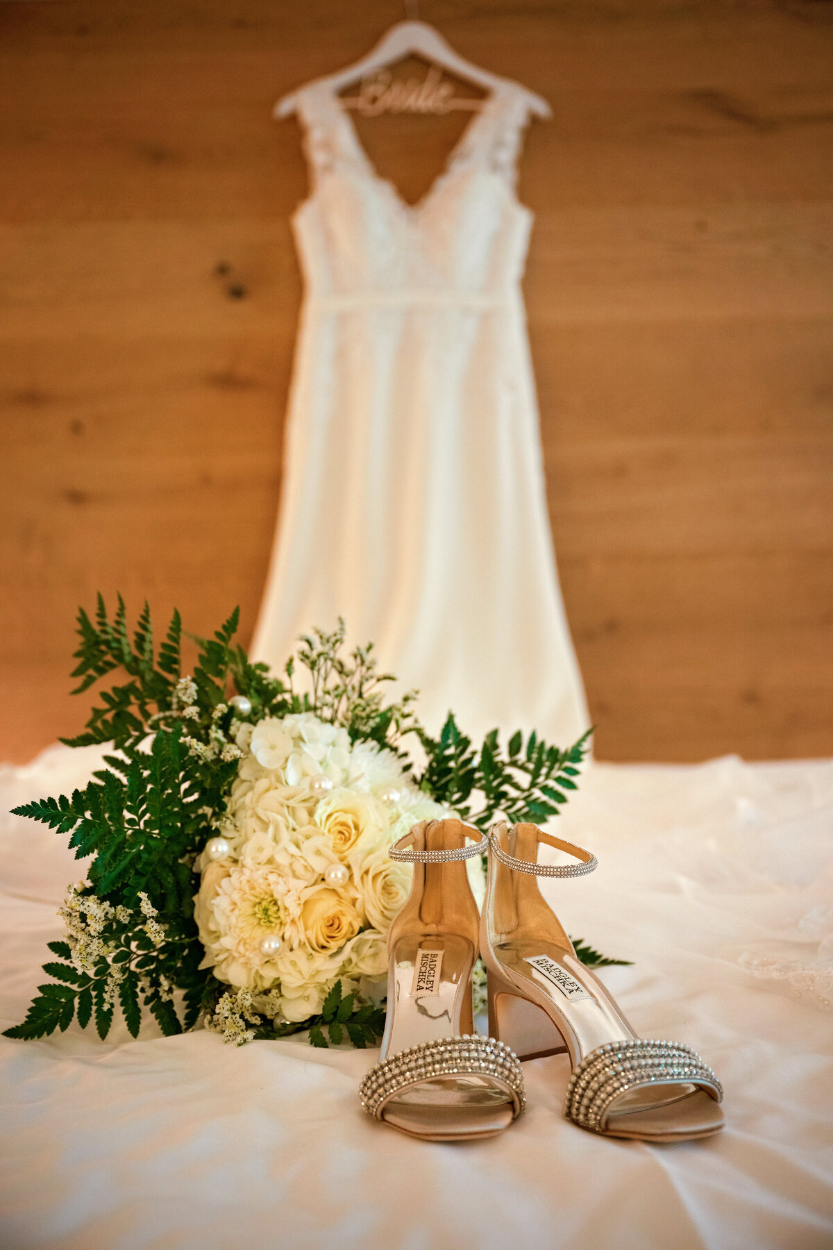 white wedding dress on a custom made bride hanger with shoes and flowers