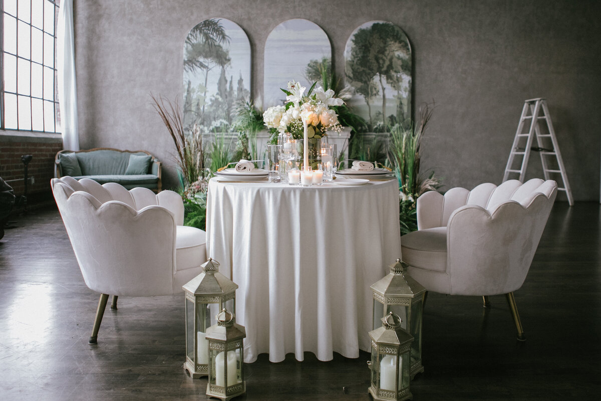 intimate wedding reception with a round table and white chairs