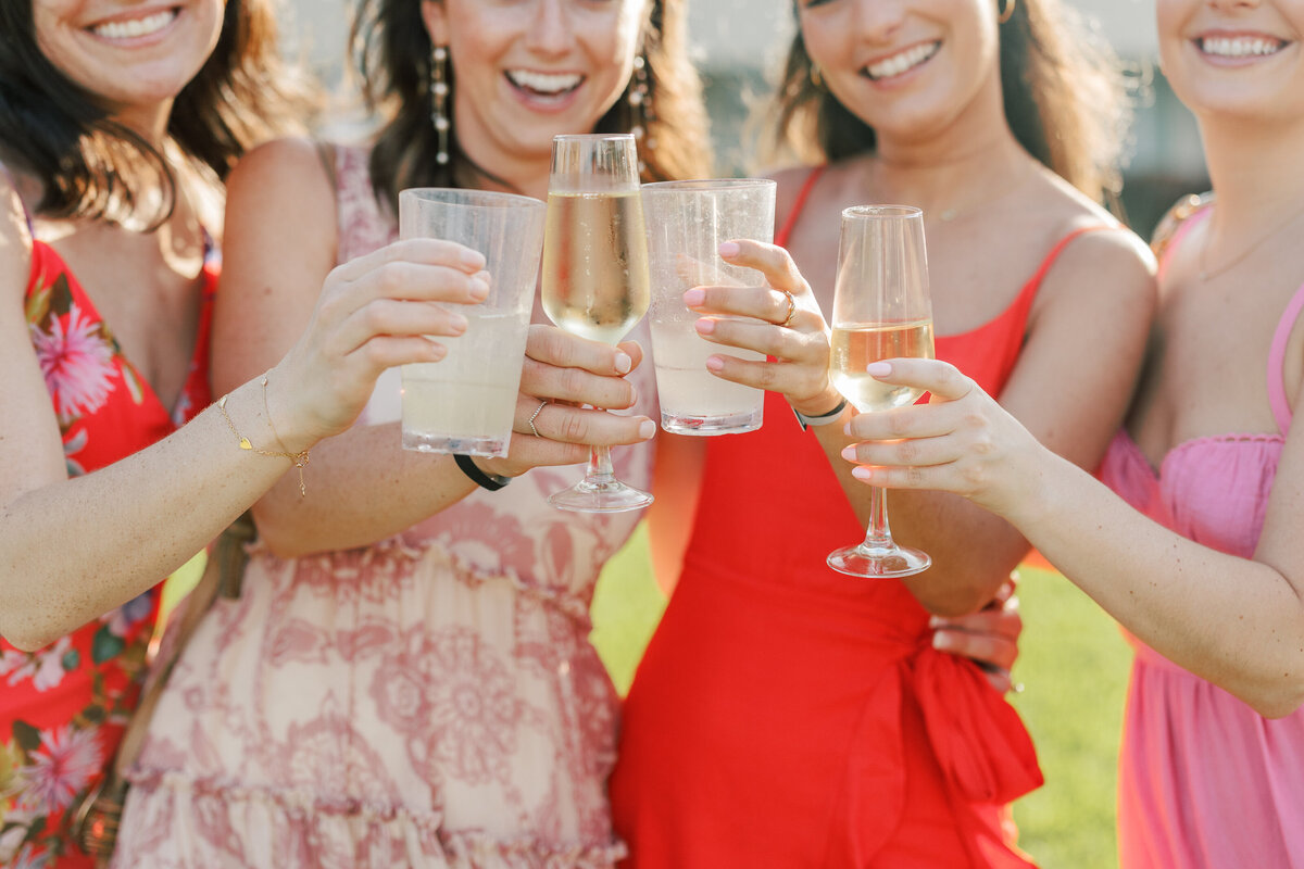 Guests toast champagne and cocktails during a sunny Cancun wedding celebration by a Philly-based wedding photographer.