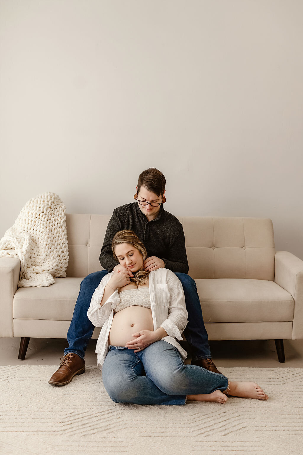 couple posed lovingly in denver photography studio for their maternity photos