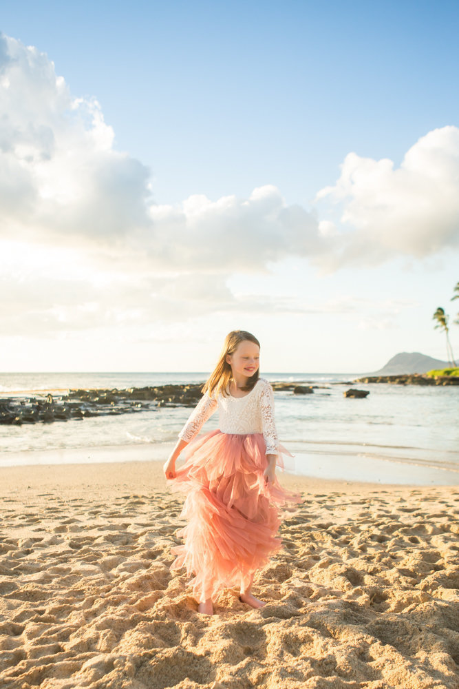 Photos of little girl dancing in the sand by Oahu family photographers  Karma Hill Photography