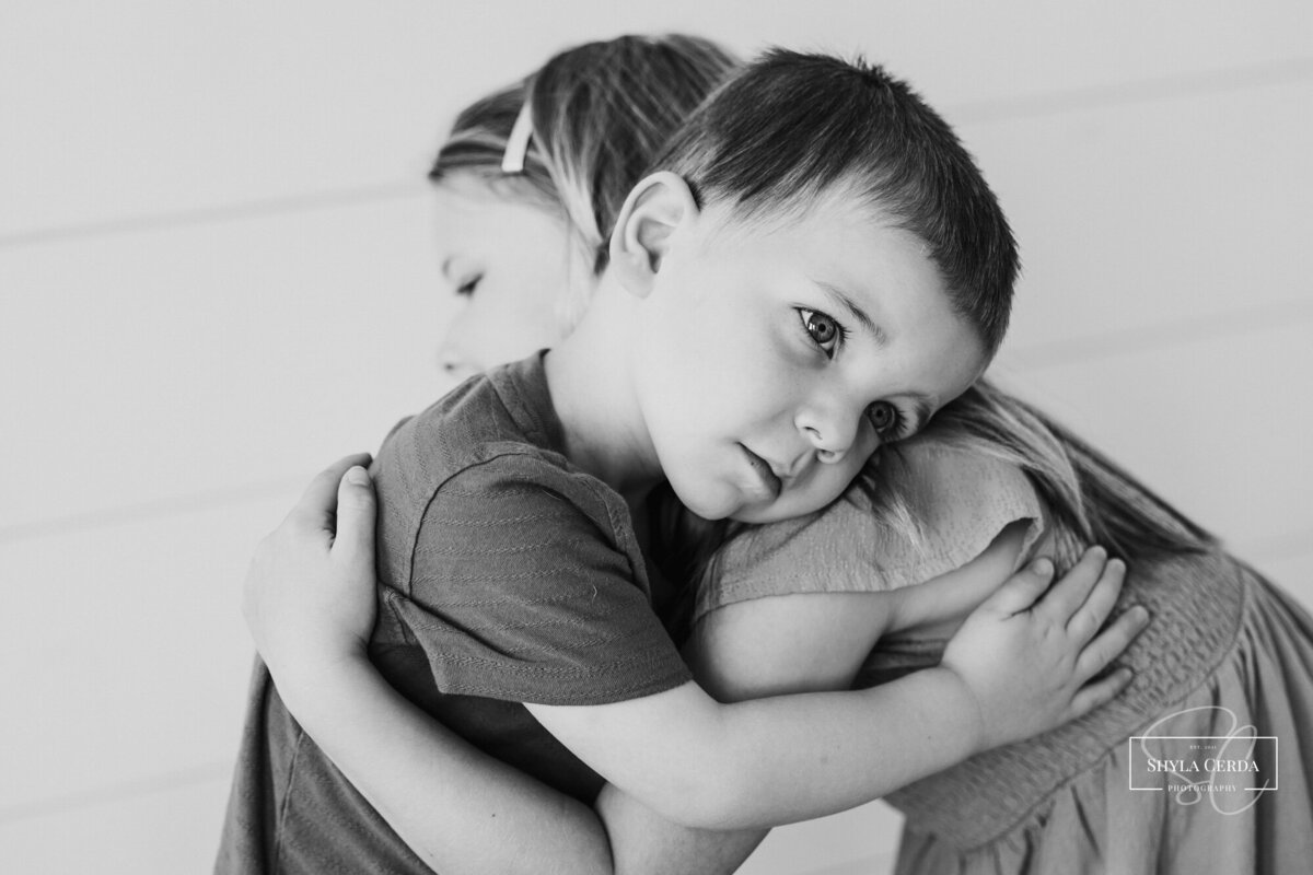 Two sibling hugging during studio session
