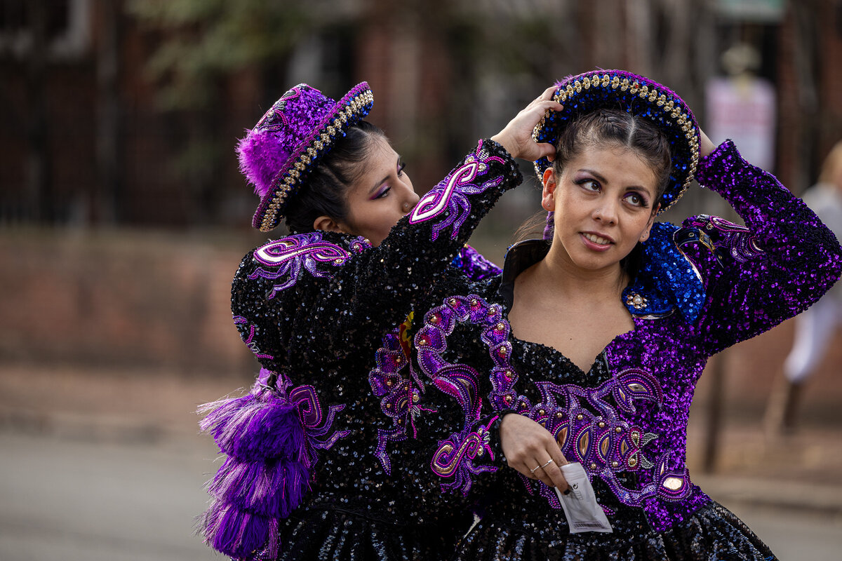 Two cultural woman in purple preparing for their dance at a local multi cultural parade, Candid moment of behind the scenes.