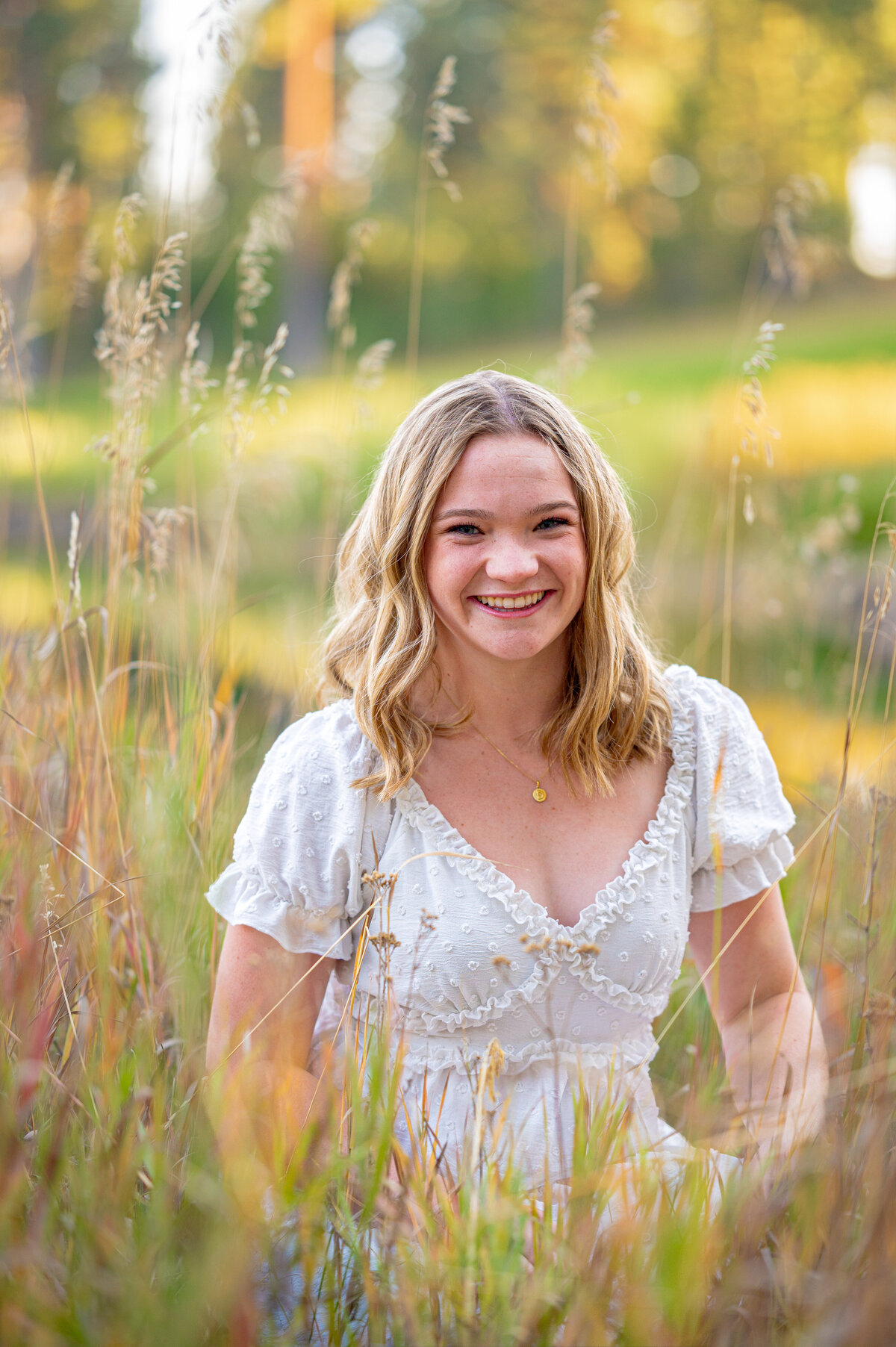 Senior smiling in a field of tall grass during sunset — joyful family photography in Fort Worth by Poppy + Blue Photography