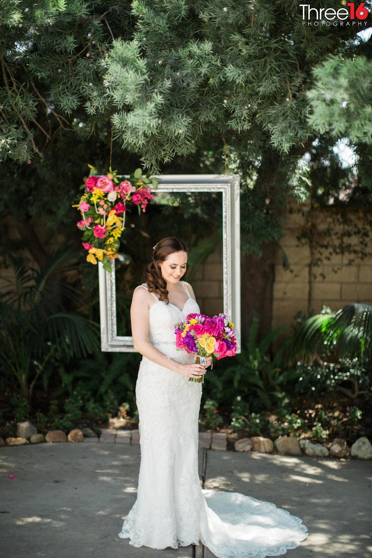 Bride poses with her bouquet and decorated picture frame