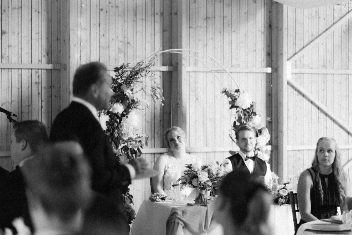 The wedding couple is listening to the speech. Image captured by wedding photographer Hannika Gabrielsson.