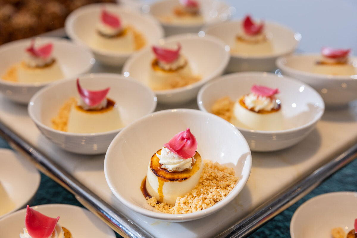 A bowl of dessert with a pink flower on top