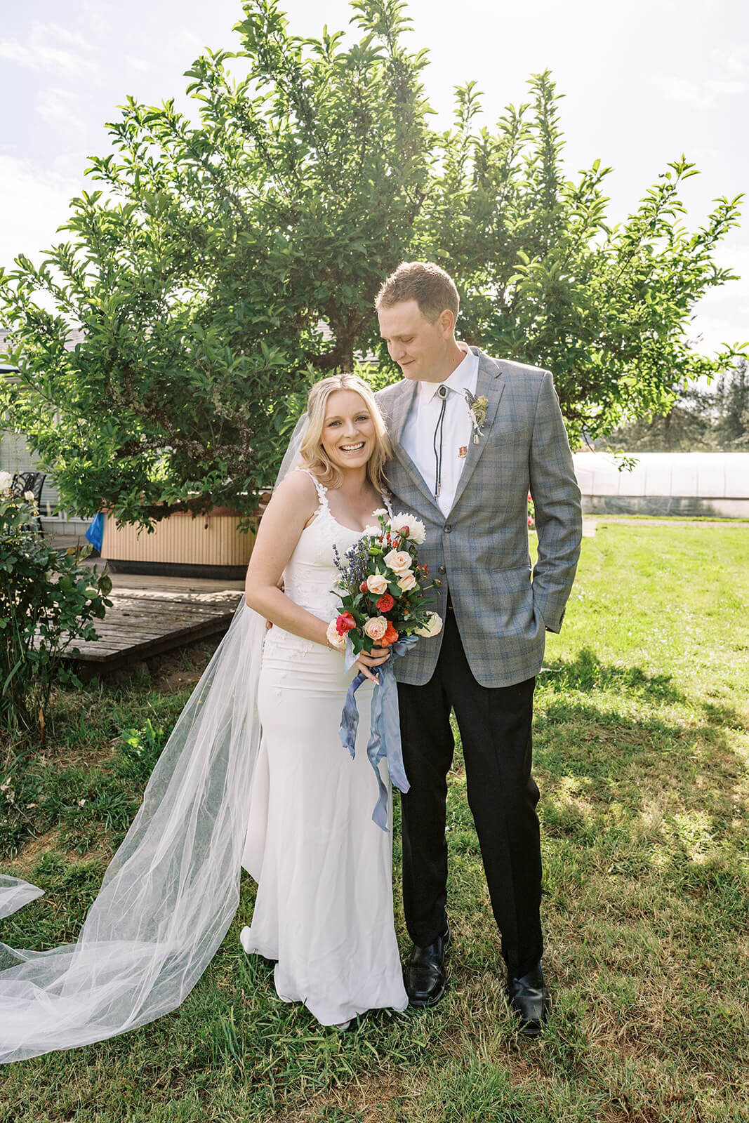 A bride and groom embracing outdoors at their Veneta farm wedding.