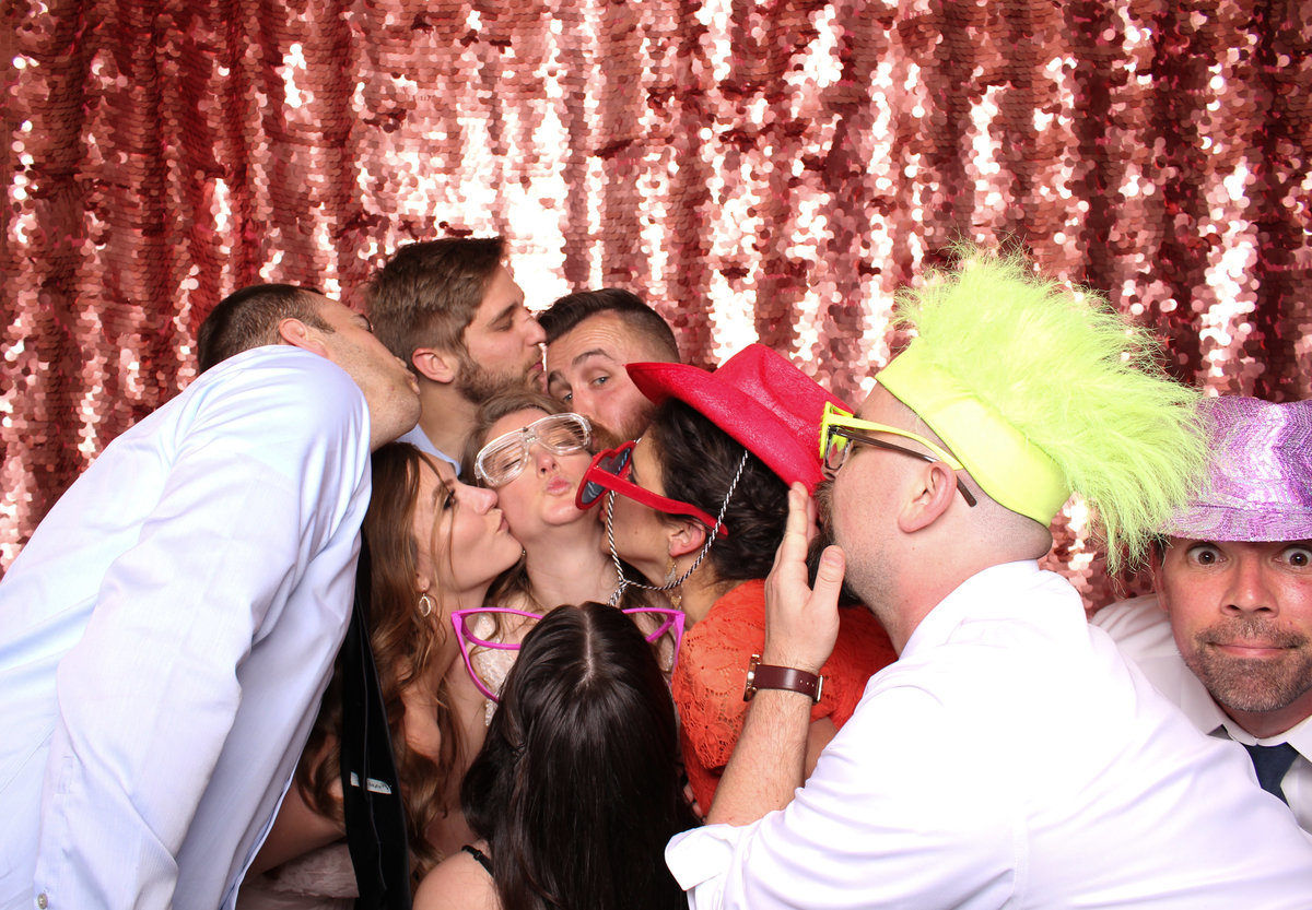 Everybody is kissy kissy at a wedding reception in a photo booth rental