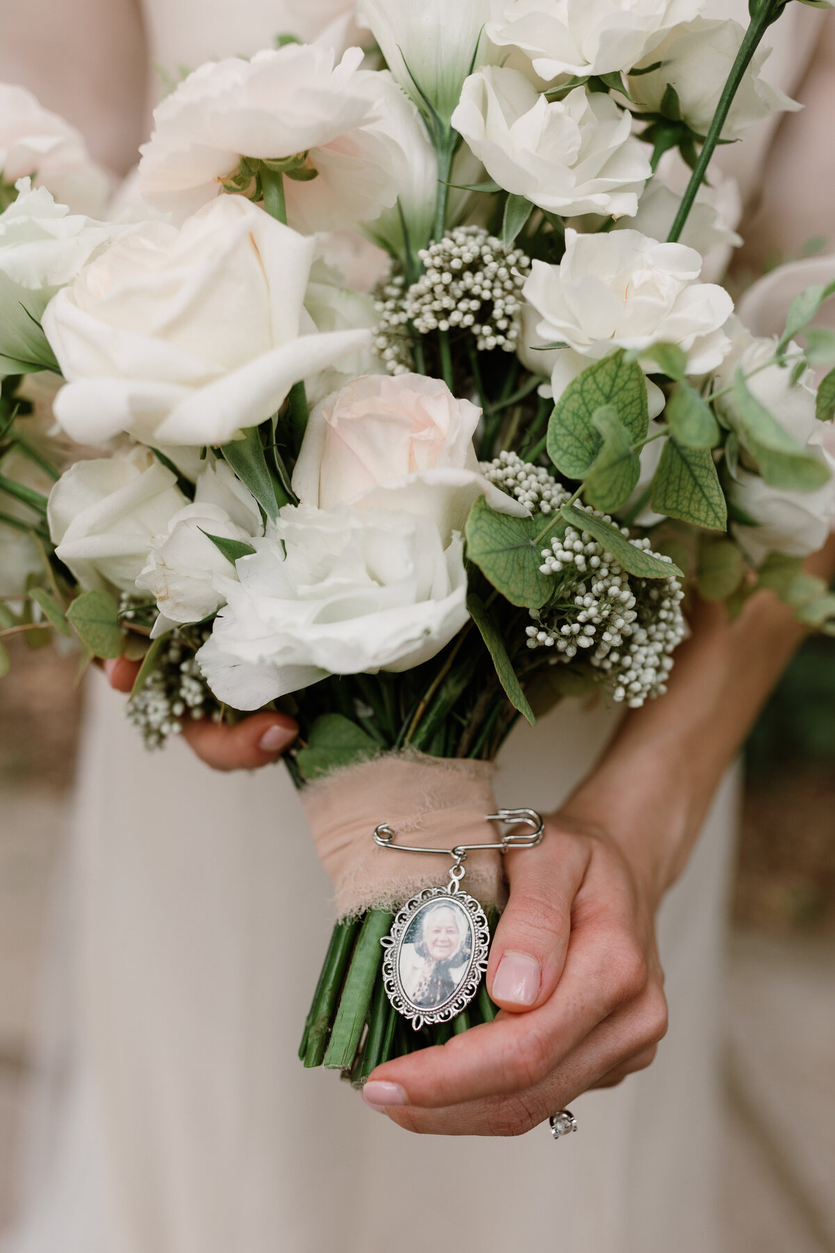 Bride holding bouquet with vintage brooch