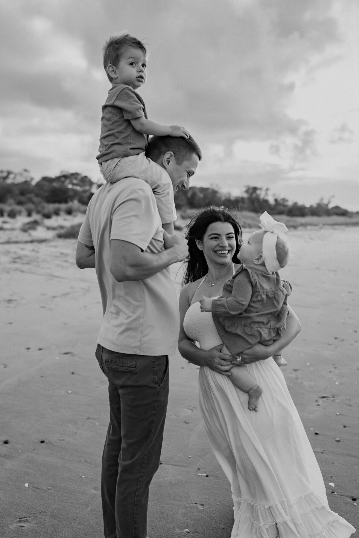 Family holding each other and laughing on the beach