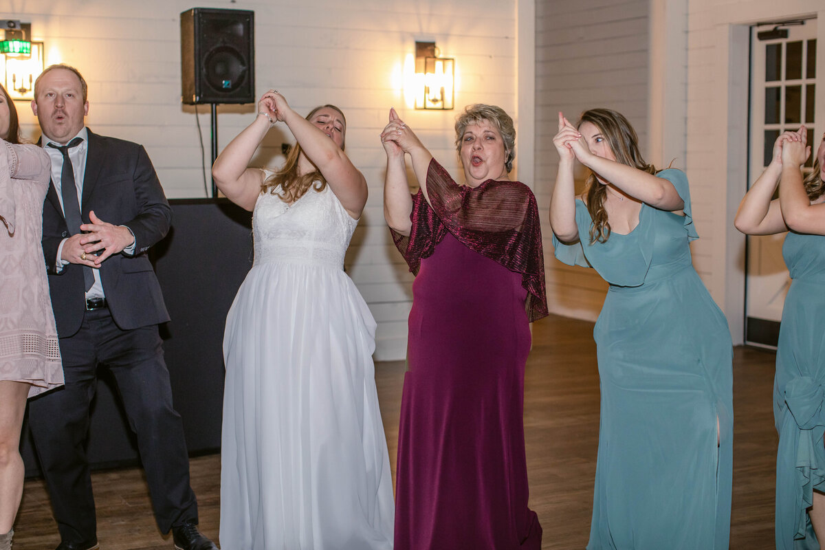 Texas Aggie wedding guests whoop with arms raised during war hymn