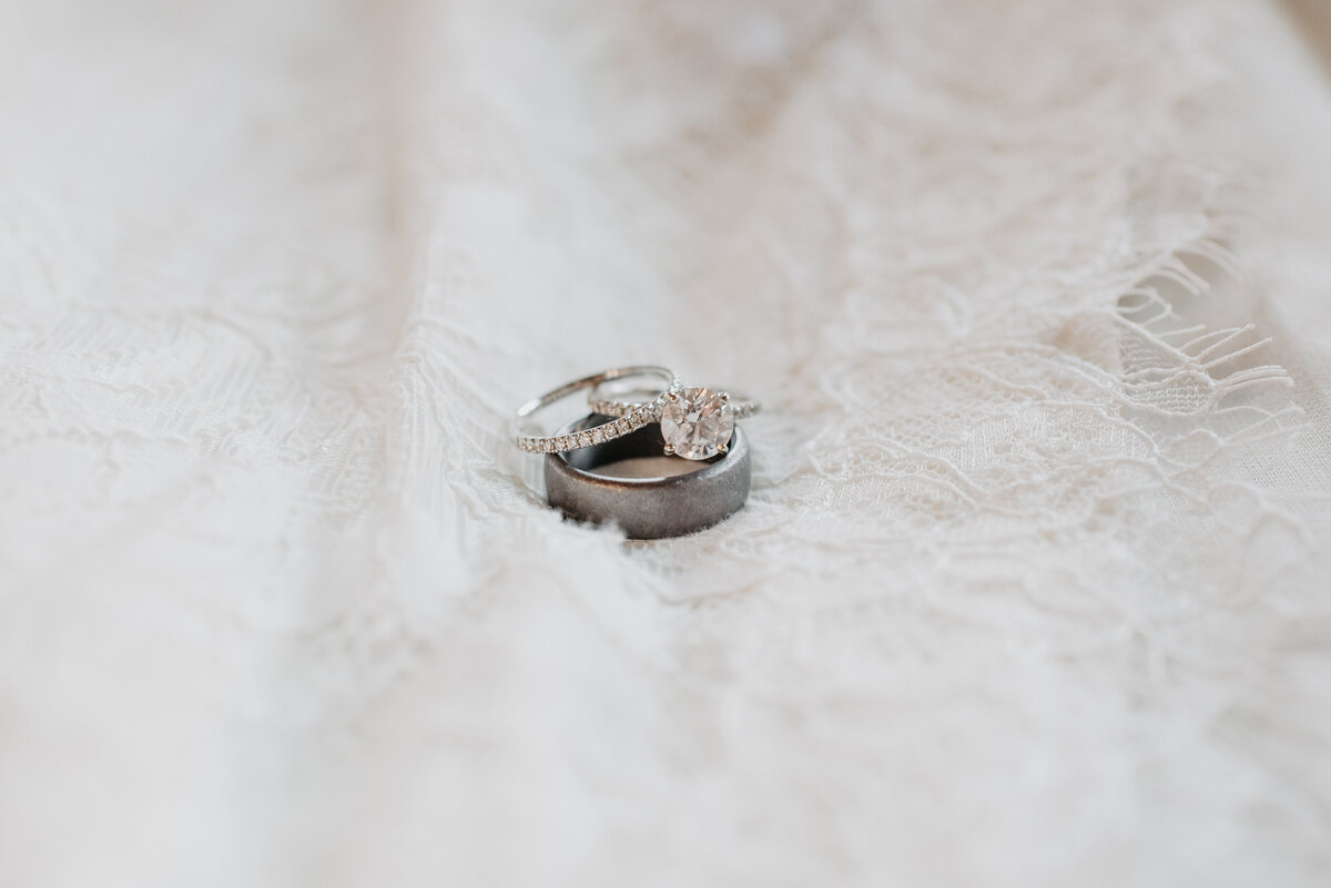 Photographers Jackson Hole capture wedding rings sitting on wedding dress