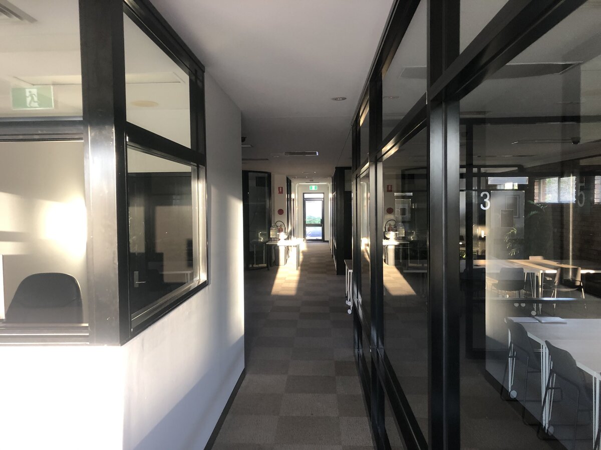 Professional office with custom glass partitions for privacy and a modern layout.