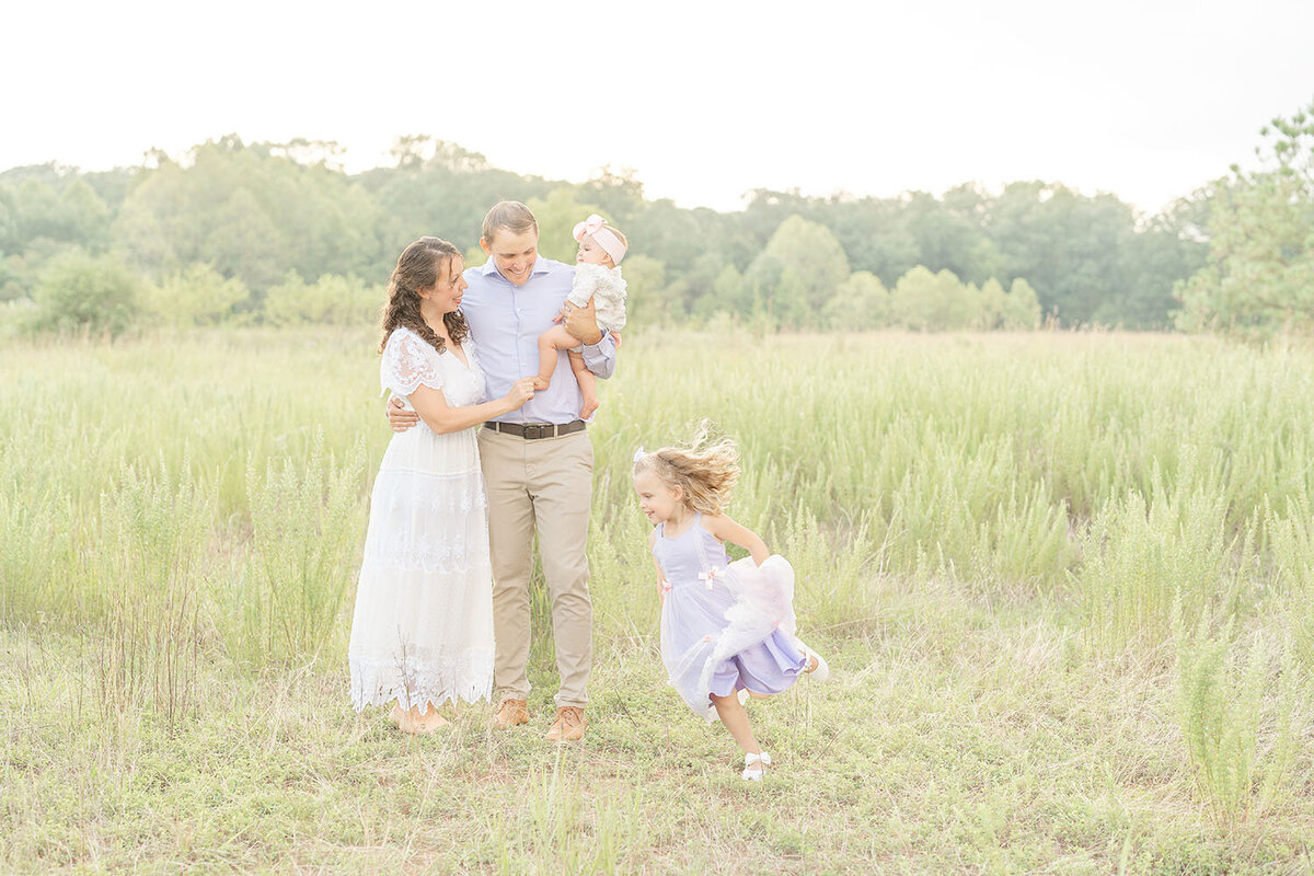 girl running around parents and baby sister in Reston, Virginia