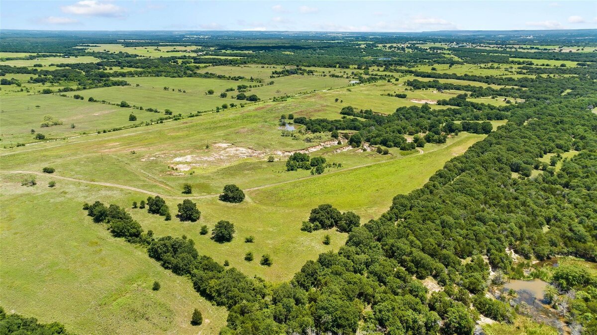 Aerial view of 55-acre property with mature post oaks in Saint Jo, TX