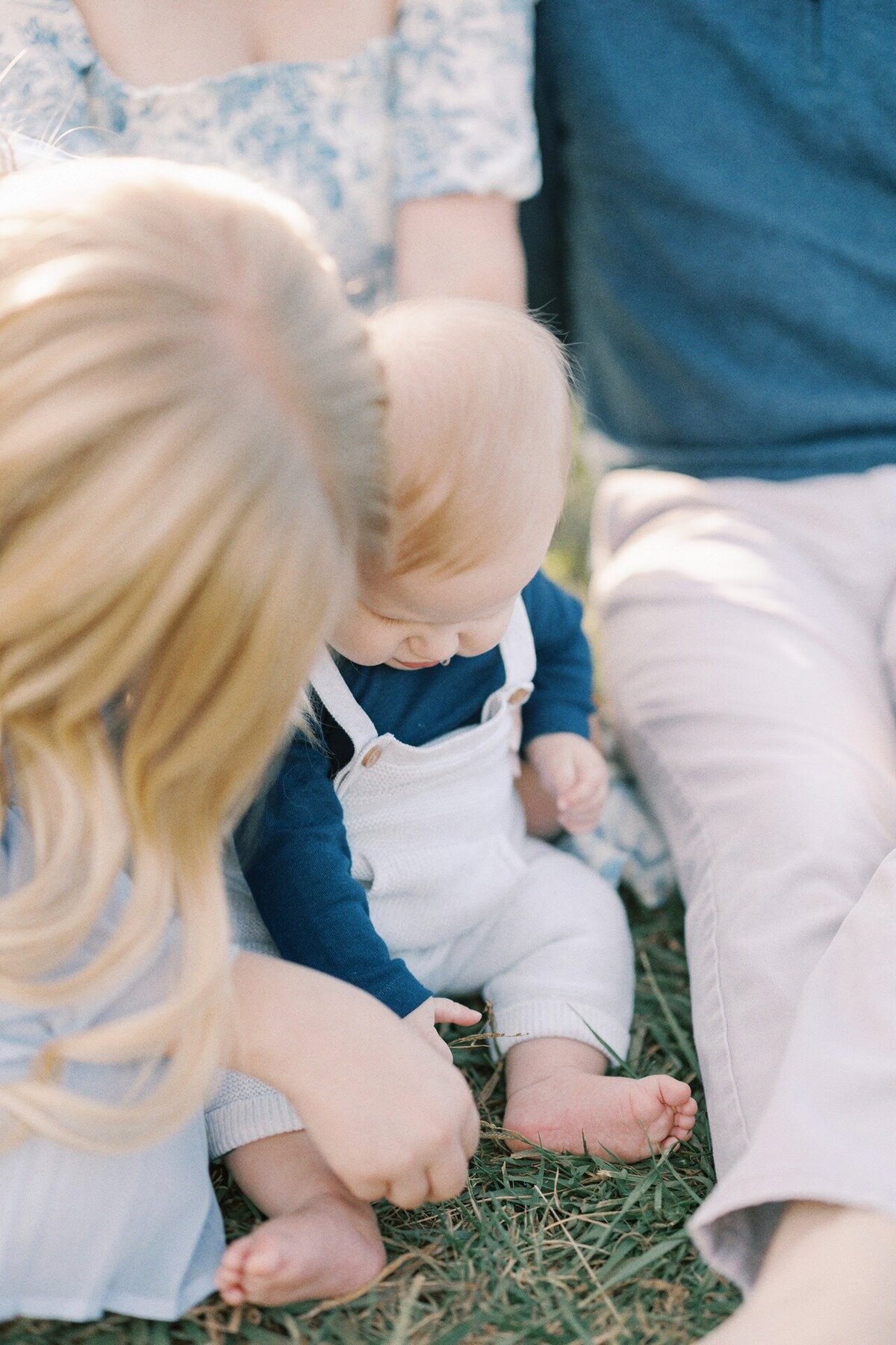 baby-playing-in-grass-with-sister