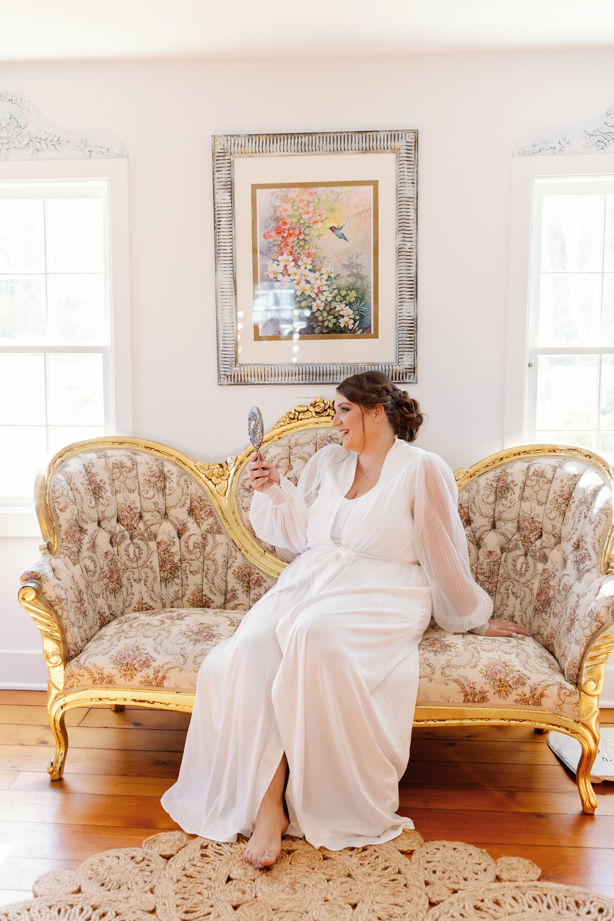 Bride posing with autumn bouquet against ornate white interior walls at The Hummingbird Chateau.