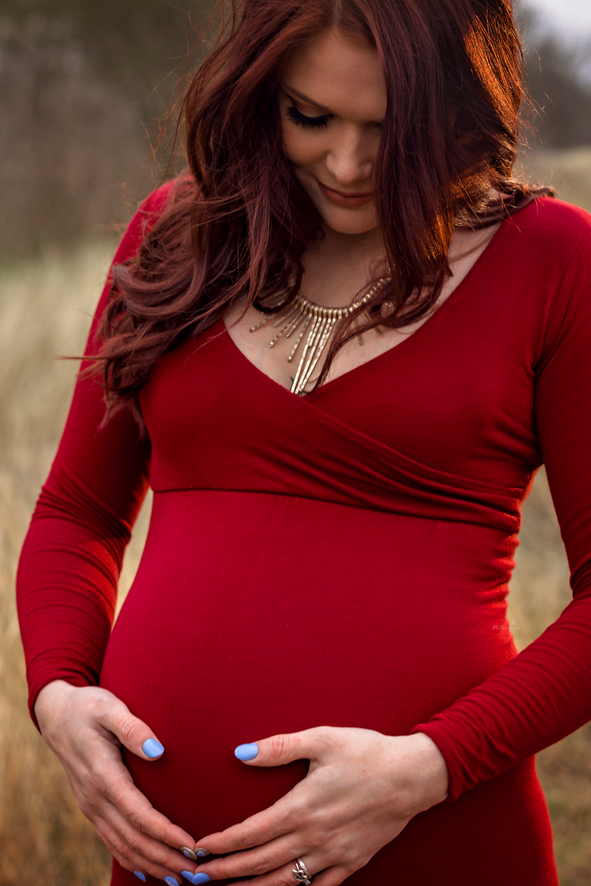 Embrace the fireside glow in a stylish winter maternity session near San Antonio. Our mom-to-be dons a scarlet flying dress, adding warmth and style to your family memories.