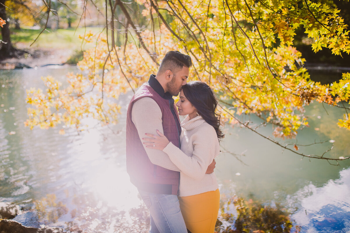 A couple embracing by the central park pool by 101st in the fall in uptown nyc
